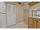 The kitchen entrance opens to a hardwood living space and features clean appliances and tile flooring at 1737 Pine Ridge W Way # B-1, Palm Harbor, FL 34684