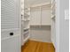 An organized walk-in closet with shelves and rods, paired with a light-colored wood floor at 1737 Pine Ridge W Way # B-1, Palm Harbor, FL 34684