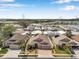 A beautiful residential neighborhood is captured in an aerial shot displaying the tidy streets, houses, and a lake in the background at 1783 Wood Brook St, Tarpon Springs, FL 34689