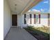 Covered front porch with a brown front door, shutters on the windows, and stone accents at 2039 Belmar Ave, Spring Hill, FL 34608