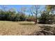 The large lot features plenty of trees and a wooden fence at 2158 Fentress Ct, Spring Hill, FL 34609
