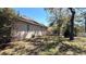View of the side of the house with a glimpse of the backyard, and trees at 2158 Fentress Ct, Spring Hill, FL 34609