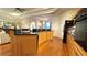 Open kitchen with wood floors, stainless appliances, wood cabinets, and granite countertops at 2158 Fentress Ct, Spring Hill, FL 34609