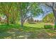 Spacious backyard with trees in a neighborhood setting with green grass at 303 Rochester St, Spring Hill, FL 34609