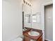 Bathroom with single sink, vanity and large mirror with lighting above and wood flooring at 303 Rochester St, Spring Hill, FL 34609