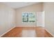 Neutral bedroom with hardwood floors, a ceiling fan, and an open door at 303 Rochester St, Spring Hill, FL 34609