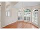 Dining room featuring laminate flooring, white walls, arched windows with white shutters, and decorative chandelier at 303 Rochester St, Spring Hill, FL 34609