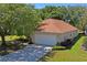 Well-maintained single-Gathering home featuring a two-car garage, tidy landscaping, and a durable tile roof at 303 Rochester St, Spring Hill, FL 34609
