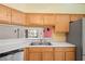 Close up of kitchen area featuring a double sink, cabinets, stainless steel appliances, and white countertop at 303 Rochester St, Spring Hill, FL 34609