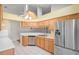 Kitchen area with stainless steel refrigerator and dishwasher, light brown cabinets, and white countertops at 303 Rochester St, Spring Hill, FL 34609