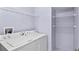 Functional laundry room with washer, dryer, and shelving providing ample storage for cleaning supplies at 303 Rochester St, Spring Hill, FL 34609