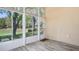 Bright sunroom with vinyl floors and large glass windows overlooking the backyard at 303 Rochester St, Spring Hill, FL 34609