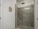Modern bathroom shower with glass door and gray tiling to waist height at 3056 Francoa Dr, Odessa, FL 33556