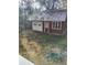 Small, red-painted shed with a white door, window and a metal roof on a partly sunny day at 315 Highland St, Brooksville, FL 34601