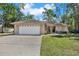 Beautiful home featuring a two-car garage, well-manicured lawn, and charming curb appeal at 3450 Dow Lane, Spring Hill, FL 34608