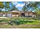 Tan house on a sunny day with a green yard at 3450 Dow Lane, Spring Hill, FL 34608
