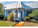 Charming home featuring a white metal roof, white stucco walls, blue shutters, and manicured landscaping at 4266 Tamargo Dr # 4266, New Port Richey, FL 34652