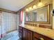 Bathroom with decorative shower, granite countertop and large framed mirror at 4420 Devon Dr, New Port Richey, FL 34653