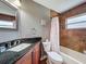 Bathroom featuring a shower-tub combo with a tile surround and granite vanity at 4420 Devon Dr, New Port Richey, FL 34653