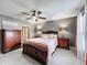 This main bedroom features wood furniture, a ceiling fan, and tile floors at 4420 Devon Dr, New Port Richey, FL 34653