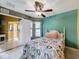 Bedroom with a ceiling fan, patterned bedspread and ensuite bathroom at 4420 Devon Dr, New Port Richey, FL 34653