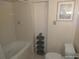 Bathroom showcasing bathtub, toilet, and tiled walls at 4607 N Saint Vincent St, Tampa, FL 33614