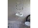 Simple bathroom features a white sink and toilet with patterned tiles at 4607 N Saint Vincent St, Tampa, FL 33614