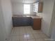 Simple kitchen with tile flooring, stainless steel sink and wood cabinets at 4607 N Saint Vincent St, Tampa, FL 33614