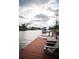 Wooden dock featuring a seating area, paddle board, and boat, providing direct waterfront access at 4964 Cedarbrook Ln, Hernando Beach, FL 34607