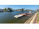 Waterfront view of a boat dock with multiple docks, and boats nearby in a canal on a sunny day at 4964 Cedarbrook Ln, Hernando Beach, FL 34607