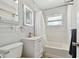 Bright bathroom featuring a pristine white vanity and shower-tub combination with elegant tile at 6250 Vermont Ave, New Port Richey, FL 34653