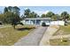 Charming single Gathering home, front view with driveway, featuring mature trees and inviting curb appeal at 6250 Vermont Ave, New Port Richey, FL 34653