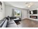 Cozy living room features a modern fireplace, dark leather sectional and light gray walls at 6250 Vermont Ave, New Port Richey, FL 34653