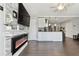 Open concept living room with modern fireplace, large TV, and sleek flooring leading into the kitchen area at 6250 Vermont Ave, New Port Richey, FL 34653