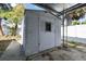 The gray storage shed with a white trimmed window is located in the backyard at 6250 Vermont Ave, New Port Richey, FL 34653