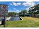 Waterfront scene with boat docks, a 'No Swimming' sign, and a caution sign for manatees at 6250 Vermont Ave, New Port Richey, FL 34653