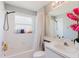 Well-lit bathroom featuring a shower and bathtub combination, vanity, and storage shelves at 7239 Sharpsburg Blvd, New Port Richey, FL 34653