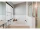 Bathroom featuring a soaking tub with shower and a large window providing natural light at 7239 Sharpsburg Blvd, New Port Richey, FL 34653