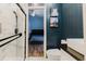 Bathroom featuring a marble shower, dark wood paneling, and decorative cat artwork at 7239 Sharpsburg Blvd, New Port Richey, FL 34653