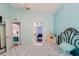 Bright bedroom featuring teal walls, connecting doors to other rooms, and comfortable furniture at 7239 Sharpsburg Blvd, New Port Richey, FL 34653