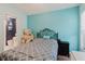 Bedroom with teal walls, wood floors, and connected bathroom showcasing modern comforts at 7239 Sharpsburg Blvd, New Port Richey, FL 34653