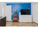 A bedroom with a blue accent wall, a dresser with a television, and decor trunks at 7239 Sharpsburg Blvd, New Port Richey, FL 34653