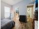 Bright bedroom featuring wood floors, decor trunks, and ensuite bathroom entrance at 7239 Sharpsburg Blvd, New Port Richey, FL 34653