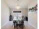 Bright dining room with glass table, chandelier, and a large window with natural light at 7239 Sharpsburg Blvd, New Port Richey, FL 34653
