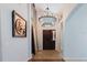 Grand foyer with a large chandelier, decorative art, and tile flooring leading into the home at 7239 Sharpsburg Blvd, New Port Richey, FL 34653