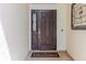 Elegant dark wood front door featuring decorative glass pane, welcome mat, and cream-colored walls at 7239 Sharpsburg Blvd, New Port Richey, FL 34653