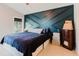 This main bedroom has a navy accent wall and a large window that provides natural lighting at 7239 Sharpsburg Blvd, New Port Richey, FL 34653