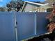 White vinyl fence with a gate offers security and privacy to the backyard and complements the home's exterior at 8434 Hazelton St, Spring Hill, FL 34608
