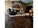 Comfortable living room with dark wood floors, area rug and large television at 8434 Hazelton St, Spring Hill, FL 34608