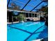 Backyard pool surrounded by a screened enclosure and patio area at 8434 Hazelton St, Spring Hill, FL 34608